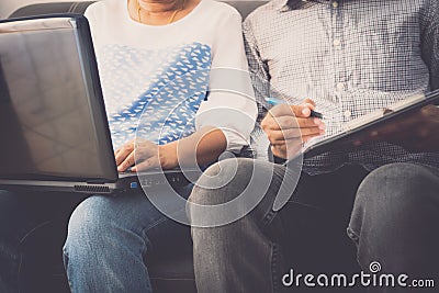 Man and woman workmate discussing together while using laptop in office Stock Photo