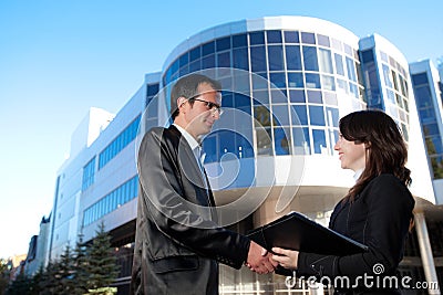 Man and woman in suits shake hands Stock Photo