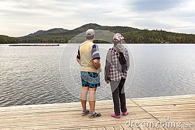 Man and women Tourists at the pier on the beautiful Ural Lake Teren Kul against the background of the Ilmensky ridge. Stock Photo