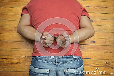 Man on wooden floor with handcuffs Stock Photo