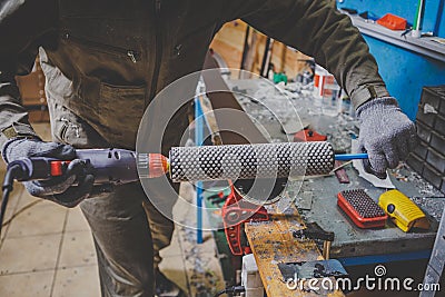 A man worker repairs in the ski service workshop the sliding surface of the skis, Base polishing, final ski polishing. In the hand Stock Photo