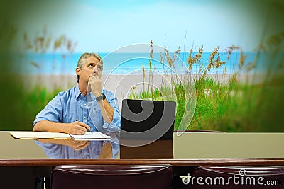 Man at work daydreaming about beautiful peaceful beach vacation Stock Photo