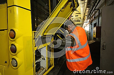 Man worker conducting technical inspection for trolleybus parked at the trolley depot hangar, depot maintenance. Kiev Editorial Stock Photo