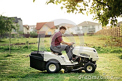 man worker cutting grass with lawn mower, lawn care concept. Industrial details Stock Photo