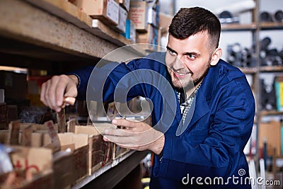 Man worker going through sanitary engineering details in workshop Stock Photo