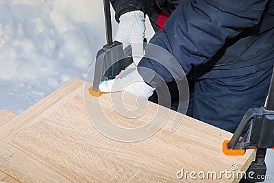 A man a worker secures the chipboard panels with two clamps Stock Photo