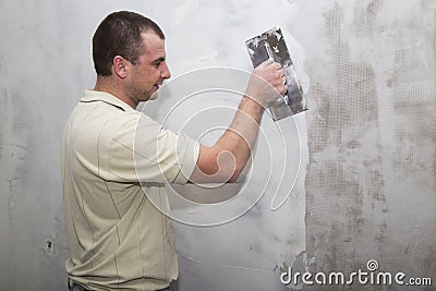 Man worker using float to apply first layer of putty Stock Photo