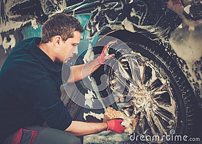 Man worker washing car's alloy wheels Stock Photo