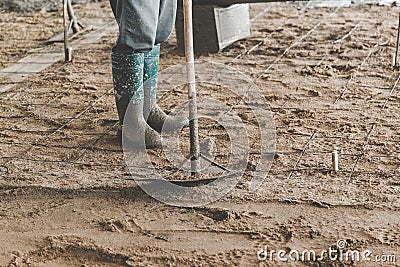 Man workers spreading freshly poured concrete mix Stock Photo