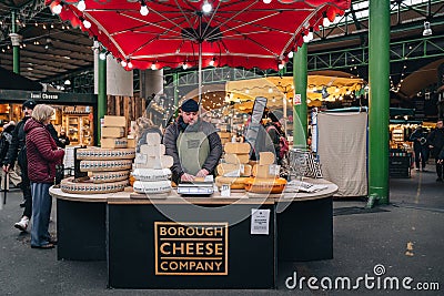 Man working at a Borough Cheese Company stall in Borough Market, London, UK Editorial Stock Photo