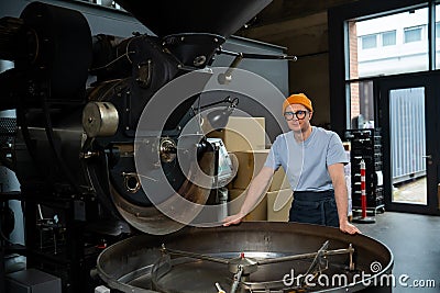 Man working in coffee roasting factory, operating process of creating coffee. Stock Photo