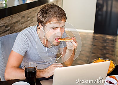 Man working at the computer and eating fast food. Unhealthy Life Stock Photo