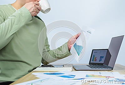 man working on document data graph and drinking coffee at home Stock Photo