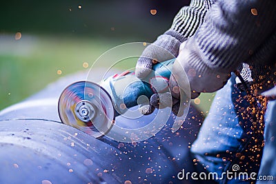 Man working with grinder saw, close up view on tool. Electric saw and hands of worker with sparks. Worker cutting metal Stock Photo