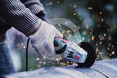 Man working with grinder saw, close up view on tool. Electric saw and hands of worker with sparks. Worker cutting metal Stock Photo