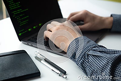 Man working on his computer. Man`s hands with laptop on white table Stock Photo