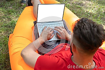 Man working on his laptop computer with blank screen. Business man typing away on his computer. Place for text on screen Stock Photo