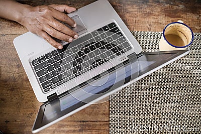 A Man Working from Home in Front of Laptop with a Cup of Coffee Stock Photo