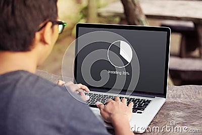 Man working and Installing update with circle load percentage waiting indicator concept on the laptop / computer screen Stock Photo