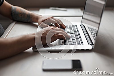 Man working on a laptop. Graphics tablet, mobile phone Stock Photo