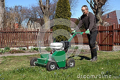 Man working with Lawn Aerator Stock Photo
