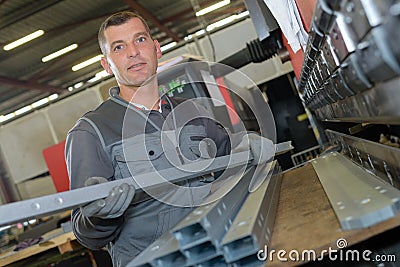 Man working with metal bars in factory Stock Photo