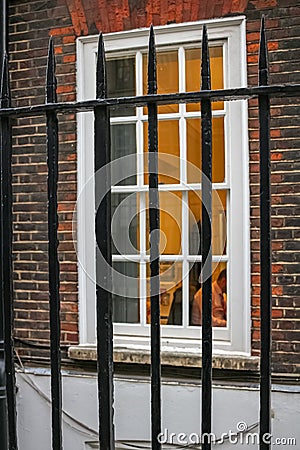 Man working at office view through grates. People are stressed because they are trapped in work place long hours Stock Photo