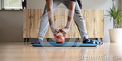 Man working out with orange kettlebell weight Stock Photo