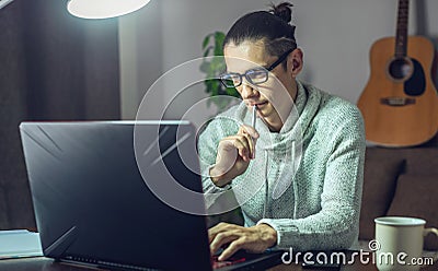 Man is working remotely using a laptop. Ability to work productively in home office mode for different professionals Stock Photo