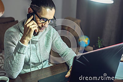 Man is working remotely using a laptop. A comfortable and convenient workplace at home for different professionals Stock Photo