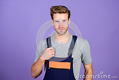 Man working in repair shop. man builder in work clothes. man build house. skilled architect repair. worker purple Stock Photo