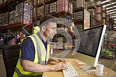 Man working in on-site office at a distribution warehouse Stock Photo