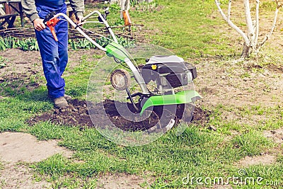 Man working in the spring garden with tiller machine Stock Photo