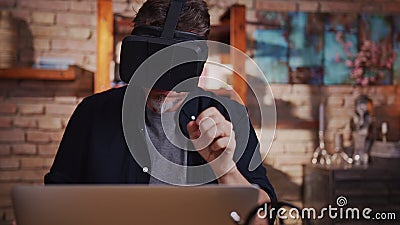 Man working with virtual reality googles at home with laptop computer on desk Stock Photo
