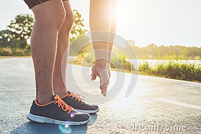 Man workout wellness concept : Runner feet with sneaker shoe running on road in the park. Focus on shoe. Shot in morning time, Stock Photo