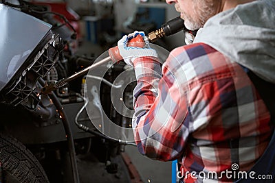 Man at a workplace in garage repairs car after accident Stock Photo