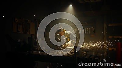 A man works with a circular saw. Worker grinder grinds metal in workshop. Sparks fly from hot metal. The man worked hard on the Stock Photo