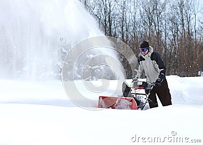 A man works snow blowing machine Stock Photo