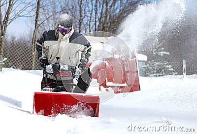 A man works snow blowing machine Stock Photo