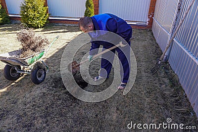 A man works in a vegetable garden in early spring Stock Photo