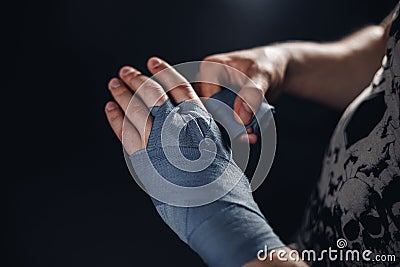 Man is wrapping hands with blue boxing wraps Stock Photo