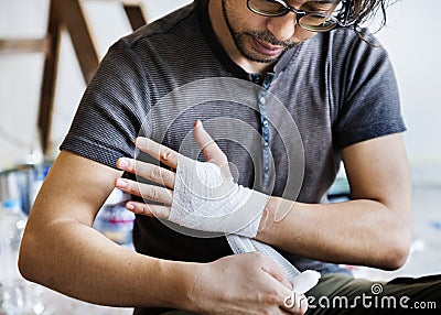 Man wrapping injured hand with bandage Stock Photo