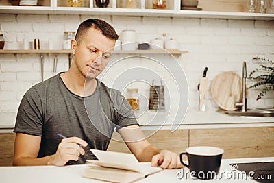 Man writing in diary drinking morning coffee Stock Photo