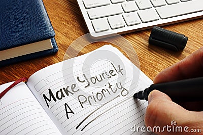 Man is writing Make yourself a priority Stock Photo