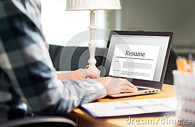 Man writing resume and CV in home office with laptop Stock Photo