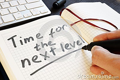 Man is writing time for the next level. Motivation. Stock Photo