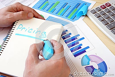 Man is writing word pricing in a note. Stock Photo