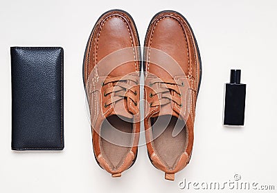 Man& x27;s look. Shoes with brown leather, a purse, a bottle of perfume on a pastel surface. Stock Photo