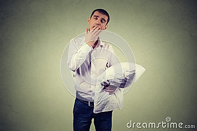 Man yawning with a pillow in hand. Sleep deprivation, burnout Stock Photo