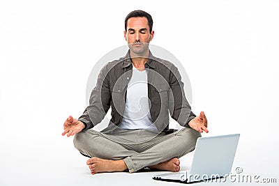 Man in yoga position with computer Stock Photo